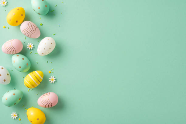 istock Decorated Easter eggs arranged on a green background with small flowers and empty area 2202118172