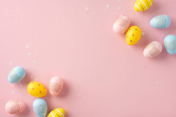 istock Pastel colored Easter eggs decorated with stripes and dots arranged on a pink surface 2202118187