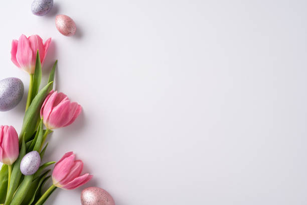 Easter-themed decoration with pink tulips and pastel-colored eggs on a light background conveying springtime joy