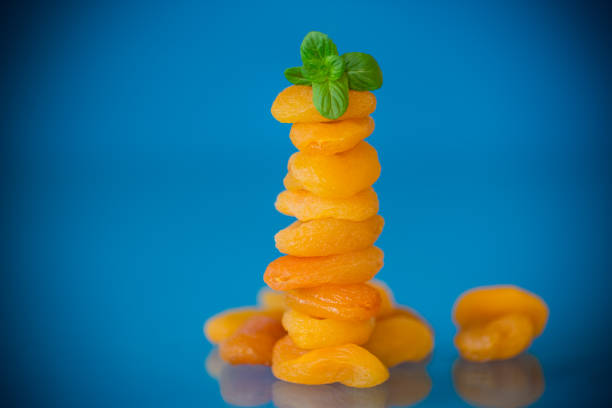 Aesthetic composition with dried apricots and fresh mint on a blue background.
