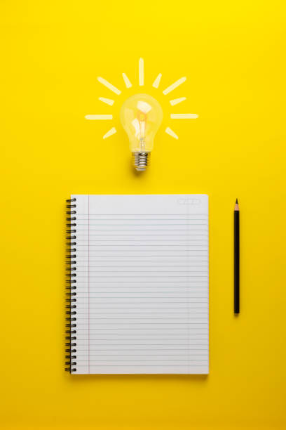 istock Creative Writing with notepad light bulb and pencil on a yellow background 2202122979