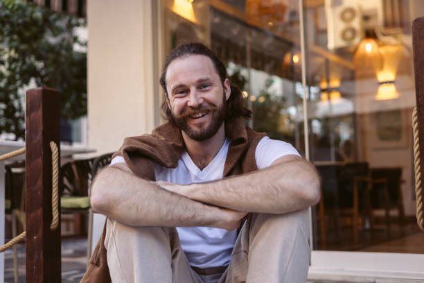 istock Relaxed man sits casually on steps in a modern outdoor space on a sunny day 2202125719