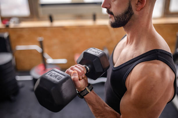 istock Muscular Man Lifting Weights in Gym Area 2202127180