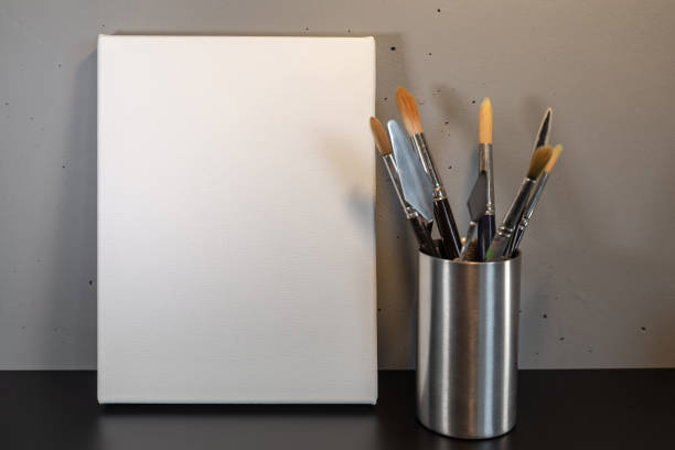 One man, painting in his home studio,, holding his brush, part of.