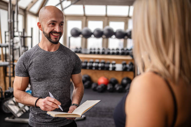 istock Personal Trainer Motivating Client in Gym 2202128083