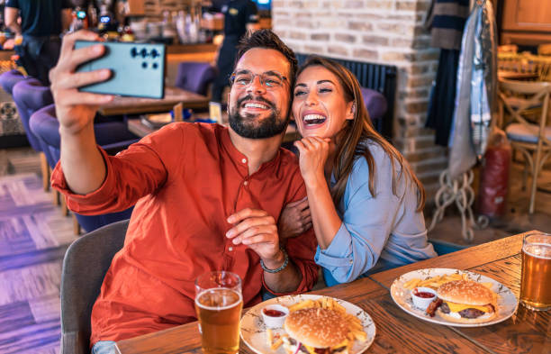 istock Couple taking a selfie while eating burgers 2202129845