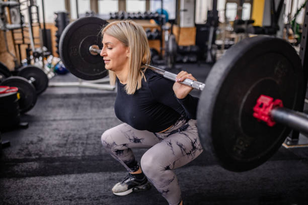 istock Strength Unleashed: Woman Performing Barbell Squats 2202130608