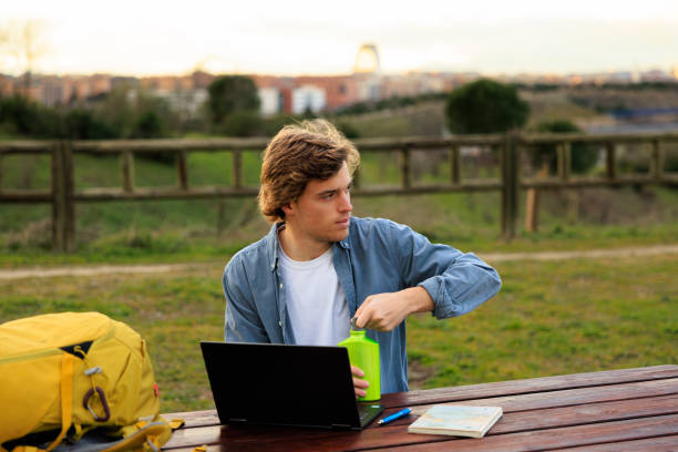 istock Backpacker enjoying a break with laptop and drink, Madrid, Spain 2202131110