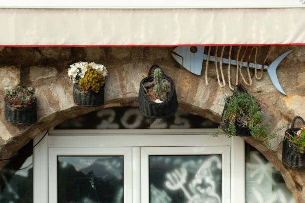 istock Rustic shopfront with plants and decorative fish, folded awning at a Mediterranean restaurant 2202132074