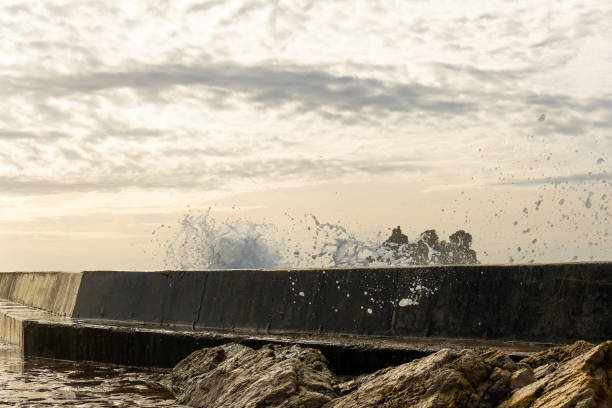 istock Wave Splashing Against Seawall at Sunset 2202133024