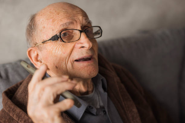 Cheerful old man having a phone conversation when talking via smart phone