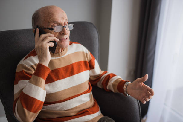 istock Elderly man sitting in a sofa and having phone conversation 2202133992
