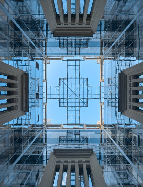 Looking up at the sky from courtyard of modern glass business center.