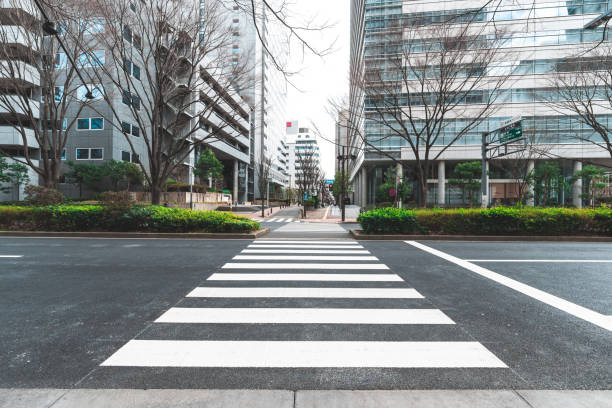 istock Empty crosswalk in tokyo business district leading to modern buildings 2202135967