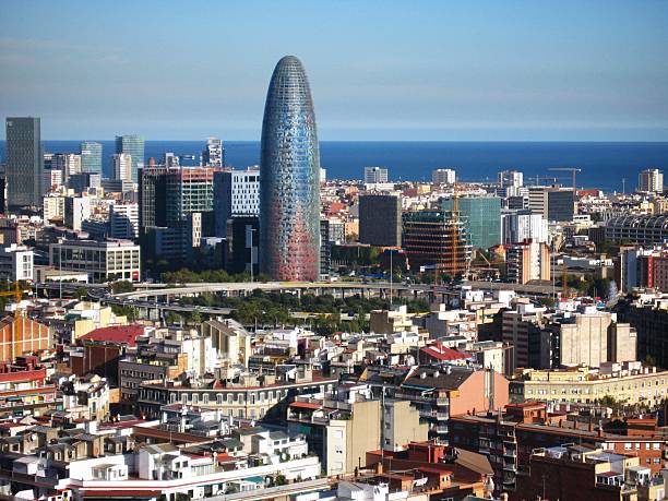 paisaje urbano de barcelona con el skyline de torre agbar. vista aérea de la ciudad, panorámica urbana de la torre agbar en barcelona. rascacielos torre agbar. vista lejana de torre agbar y el mar mediterráneo. barcelona, españa - el distrito financiero de barcelona fotografías e imágenes de stock