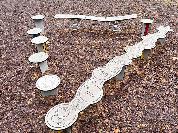 Playground stepping stones and spring balance beam on mulch, lifestyle