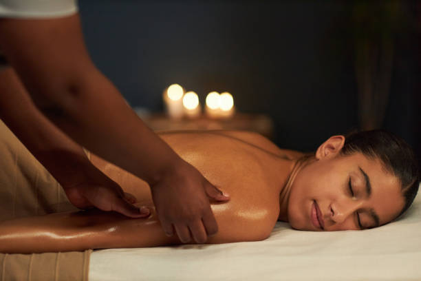 istock Receiving Relaxing Massage in Cozy, Candlelit Setting 2202137585