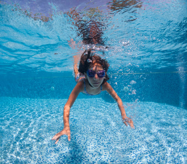 istock Smiling young girl diving underwater. 2202137827