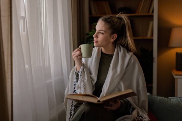 istock Young women reading book at home 2202137952