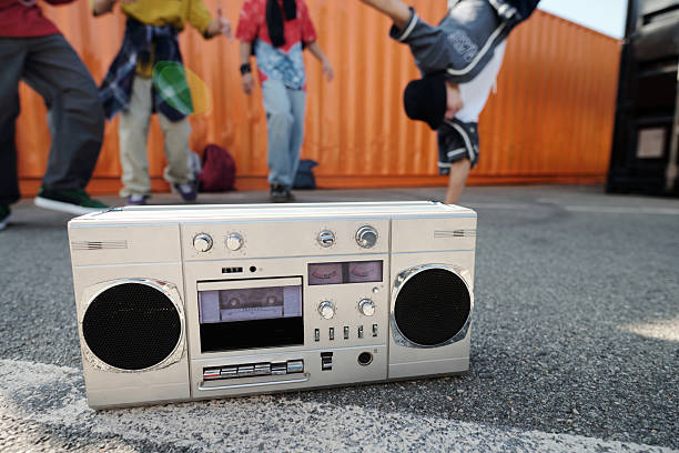 Orange stereo system with hand placing CD on open tray against retro stripes. Concept of retro, nostalgia, y2k style, poster. Photocopy effect