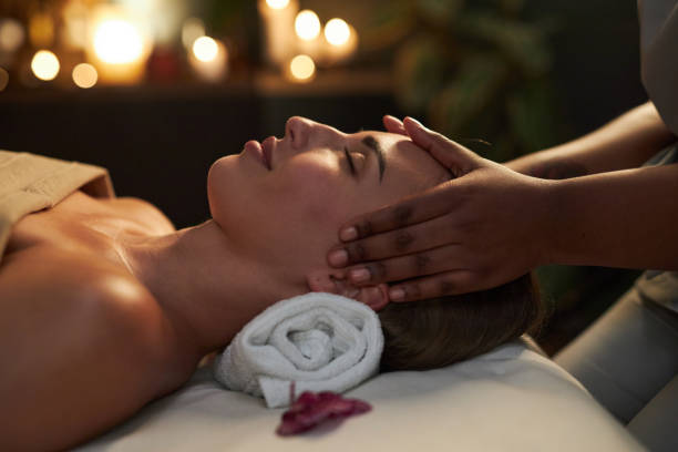 istock Receiving Relaxing Head Massage in Dimly Lit Spa Setting 2202139035