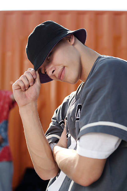 Smiling Young Man Wearing Hat Covering Partially Removing