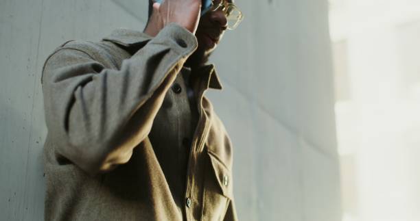 istock African-American man is using a mobile phone while walking in the city 2202140606