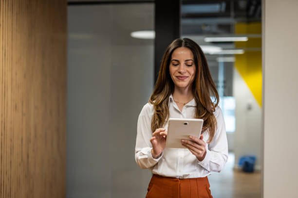 istock Smiling businesswoman using digital tablet in modern office 2202141271