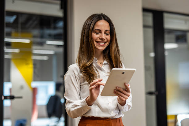 istock Smiling businesswoman using digital tablet in modern office 2202141303