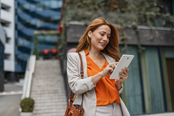 istock Happy woman standing confidently with a tablet. 2202141322