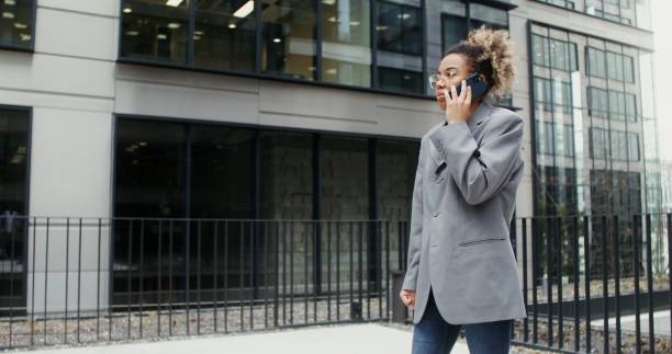 istock A woman using mobile phone while standing near an office building 2202141713