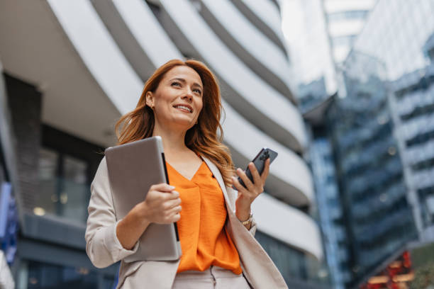 istock Stylish businesswoman navigating tech in city scene 2202141807