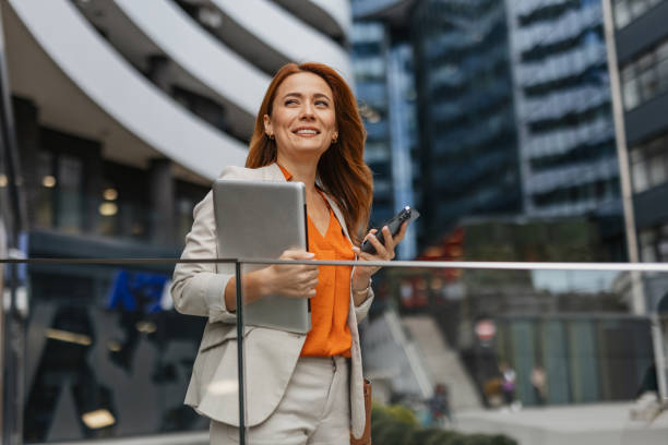 istock Confident woman outdoors with tablet and phone 2202141939