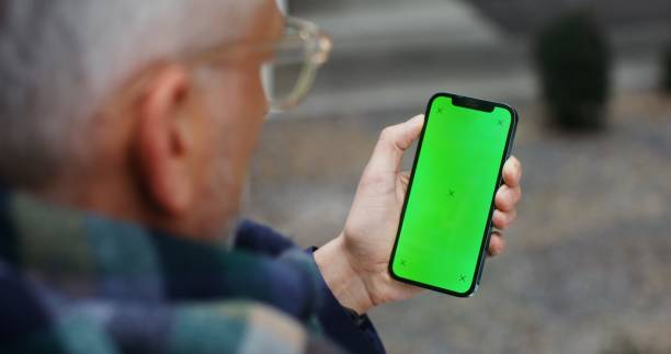 istock A warmly dressed man holds a green screen phone 2202142505