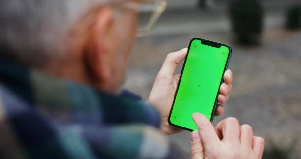 istock A warmly dressed man holds a green screen phone 2202142513