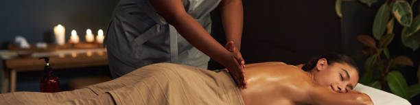 istock Receiving Relaxing Massage in Candlelit Spa Room 2202144366