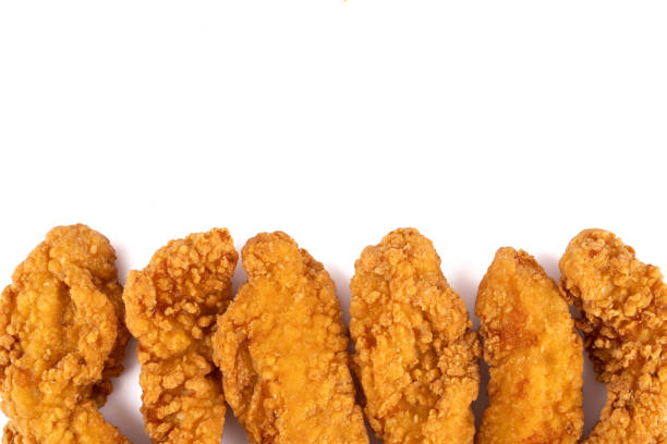 A piece of fried chicken is sitting on a white background. The chicken is golden brown and crispy, with a slightly charred flavor. Concept of indulgence and satisfaction