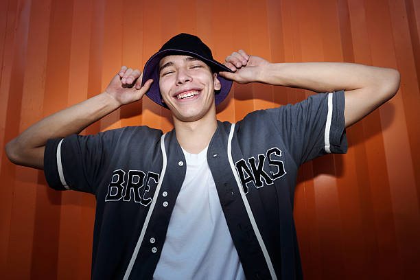 istock Smiling Young Man Holding His Hat and Laughing 2202146171