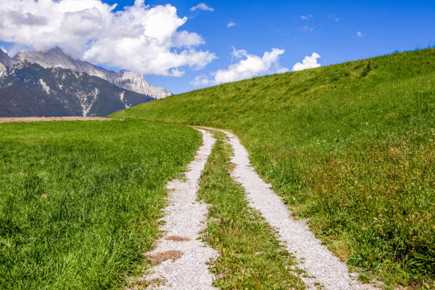 Winding road passes through picturesque valley. Yellowed grass of alpine meadows. Krimml Falls are one of the most beautiful natural areas of the Austrian Alps.