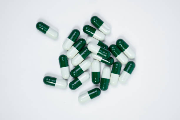 istock Capsules Packed with Nutrients and Vitamins, white or green capsules on white background 2202148656