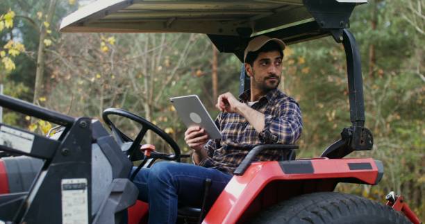 istock A young man uses a tablet while sitting in a standing agricultural machine 2202155756