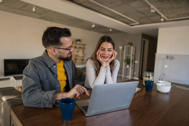 istock Young couple watching something on laptop at home 2202157719