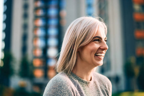istock Smiling Woman in Urban Setting with Bright Daylight 2202159820