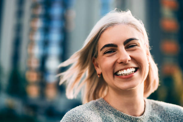 istock Smiling Woman Posing Outdoors With Urban Building Backdrop 2202159821