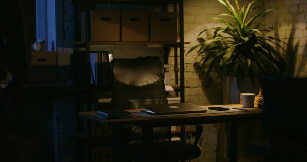 istock A young man comes to the office at night, opens a laptop and starts working 2202159883