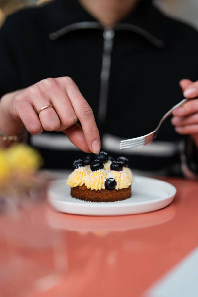 istock A Woman Eating Sable Breton, mini tart 2202160570