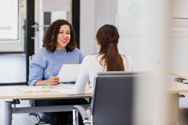 istock Two Women in Business Casual Discussing Documents 2202161387