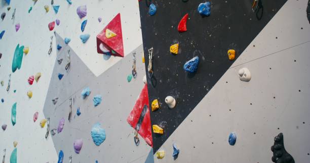 istock A man wearing a safety belt climbing up the climbing wall 2202161436
