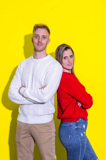istock Confident young adults posing against bright yellow background 2202164577