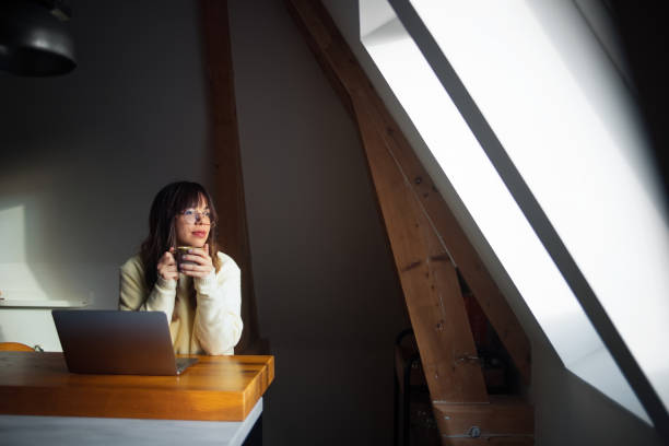 Woman Working Remotely While Enjoying Coffee in a Bright Modern Space